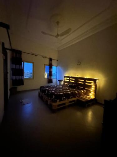 Habitación oscura con cama en una habitación con luces. en Timba Murilog, en Cotonou