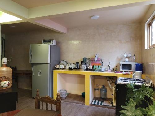 cocina con nevera y mesa amarilla en Siempre Viva, en Chignahuapan