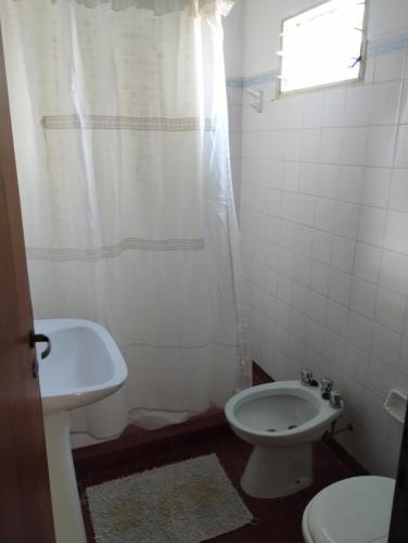 a bathroom with a white toilet and a sink at Depto en Concordia in Concordia