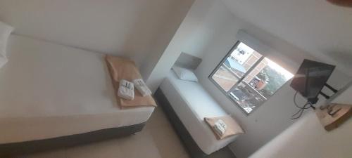 um pequeno quarto com uma cama e uma janela em Suite Gold Hotel Omaga em El Peñol