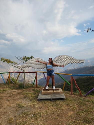 a woman standing on a platform with an eagle statue at HOTEL CAMPESTRE ABRAZO DEL ANGEL in Aratoca
