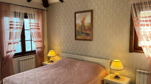 a bedroom with a bed and two tables with lamps at Villa Kulik in Donji Morinj