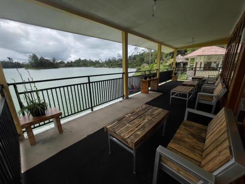 a porch with benches and a view of the water at Villa Situ Patenggang in Ciwidey