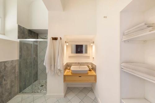 La salle de bains blanche est pourvue d'un lavabo et d'une douche. dans l'établissement Villa Mundis Relais, à Massa Lubrense