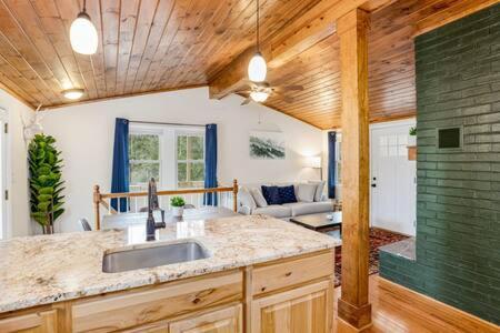 a kitchen with a sink and a living room at Harpers Ferry Cabin w Hot Tub, Huge Deck, Firepit, & WiFi! in Harpers Ferry