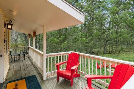 a porch with two red chairs on a house at Harpers Ferry Cabin Hot Tub, Deck, Fire Pit, WiFI in Harpers Ferry