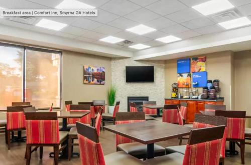 comedor con mesas y sillas y TV en Comfort Inn & Suites Atlanta-Smyrna, en Atlanta