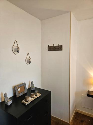 a room with a black dresser and two lights on the wall at Maison de village 6 à 8 personnes in Le Fossat