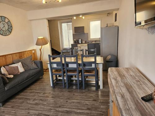 a kitchen and living room with a table and a couch at Maison de village 6 à 8 personnes in Le Fossat