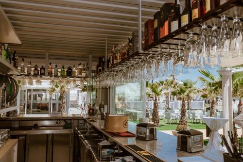 a kitchen with a bar with glasses hanging from the ceiling at Hotel & Spa Entremares in La Manga del Mar Menor