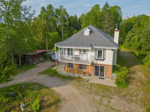 an aerial view of a house on a dirt road at Spacious cottage in forest with spa in La Macaza