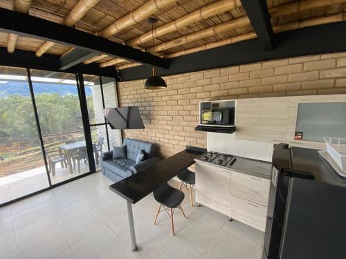a kitchen with a table and a couch in a room at Springfield Ecoloft- Guatapé in Guatapé