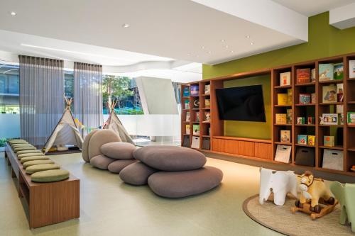 a living room with a couch and a tv and books at Lumina at Taman Condesa in Mexico City