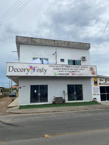 un edificio blanco con un cartel en el costado en Residência Ever’s, en Jaguaruna