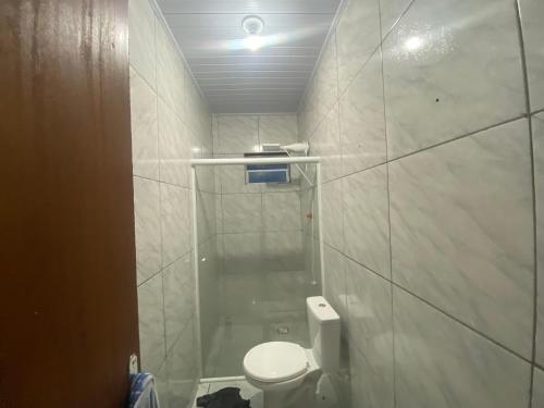 y baño pequeño con aseo y ducha. en Residência Ever’s en Jaguaruna