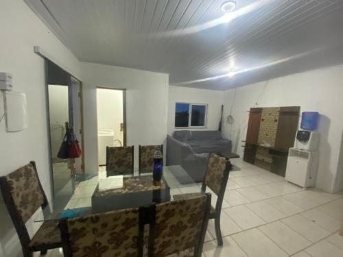 einen Esstisch und Stühle im Wohnzimmer in der Unterkunft Residência Ever’s in Jaguaruna