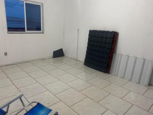 um quarto com piso em azulejo e uma janela em Residência Ever’s em Jaguaruna
