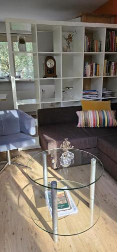a living room with a glass table and a couch at Dennenhuis in Vaassen