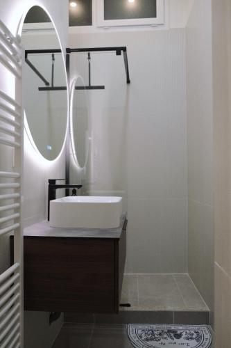une salle de bain avec un lavabo et un miroir dans l'établissement Appartement mezzanine contemporain hypercentre Caen - chez Jannie, à Caen