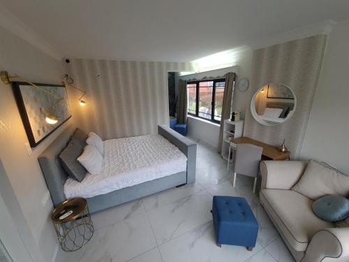 a small bedroom with a bed and a couch at Lazy Olives in Tongeren