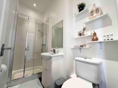 e bagno con servizi igienici, doccia e lavandino. di 2 Bed- Muswell Hill- City Views! a Londra