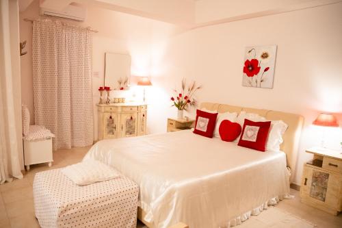 una camera da letto con un grande letto bianco con cuscini rossi di B&B Flower House a Fasano