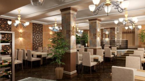 a dining room with white tables and chairs at Hotel Mimoza in Razgrad