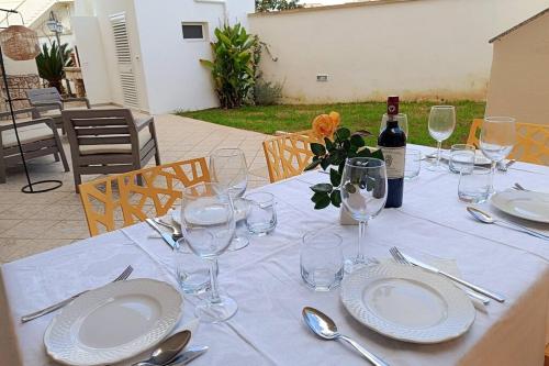 a table with plates and glasses and a bottle of wine at LA PERLA, comfort e relax in Vignacastrisi