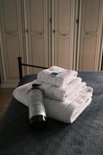 un mucchio di asciugamani su un letto con una bottiglia di sapone di Crosa Vacanze by PortofinoVacanze a Santa Margherita Ligure