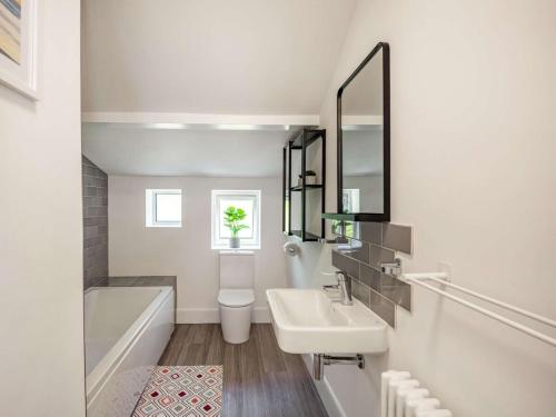a bathroom with a sink and a tub and a mirror at 2 Bed in Sway 87885 in Sway