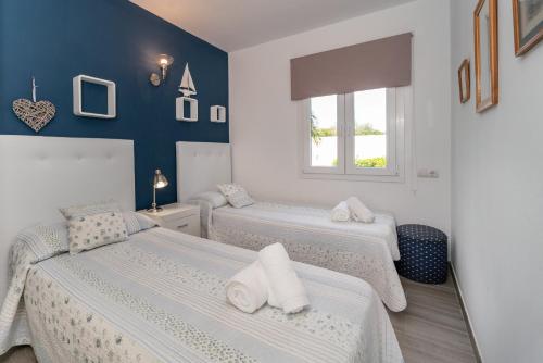 a bedroom with two beds and a window at La vista del angel in Son Bou