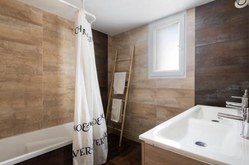 a bathroom with a sink and a shower curtain at Villa Odys in Rivedoux-Plage