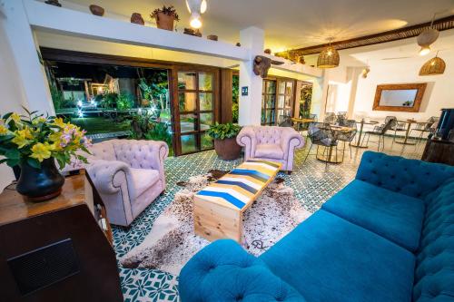 a living room with a blue couch and chairs at Terasu Hotel Boutique Salento in Salento