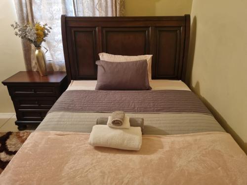 a bed with two towels sitting on top of it at Charming 2-Bed House in Portmore gated community in Portmore