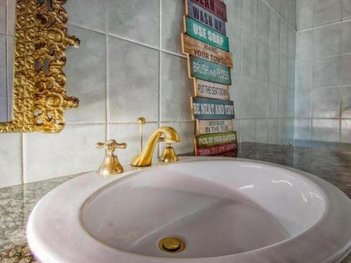 a white sink with a gold faucet in a bathroom at GSpot94 in Johannesburg