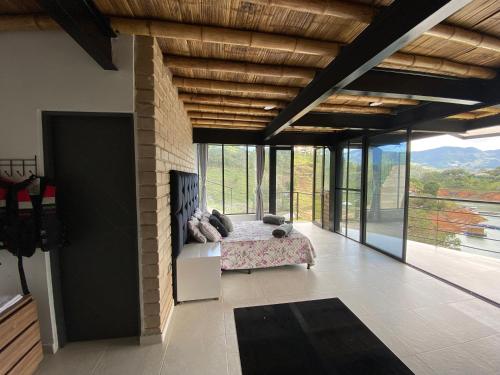 a bedroom with a bed in a room with windows at Springfield Ecoloft- Guatapé in Guatapé