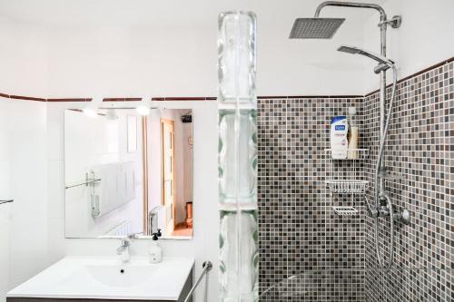 ein Bad mit einer Dusche, einem Waschbecken und einer Dusche in der Unterkunft Cals Avis Casa con Jardín en Banyoles in Banyoles