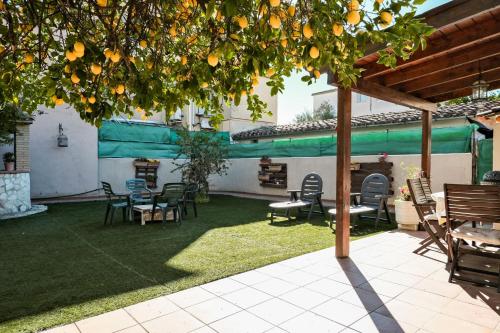 eine Terrasse mit Stühlen und Tischen unter einem Baum in der Unterkunft Cals Avis Casa con Jardín en Banyoles in Banyoles