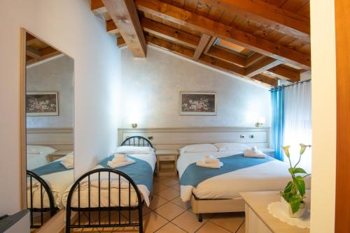 a bedroom with two beds and a mirror at Residenza Villa Bella 2 in Mozzecane