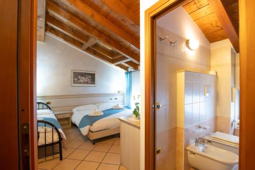 1 dormitorio con 1 cama y baño con lavamanos en Residenza Villa Bella 2, en Mozzecane