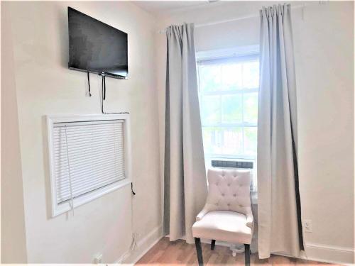 ワシントンにあるGrandeur Room in Washington DCの壁にテレビと椅子が備わる客室です。