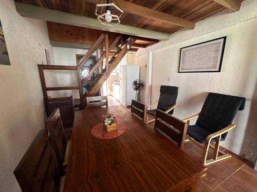sala de estar con mesa y sillas y escalera en casa de playa barra del chuy alborada duplex 2, en Barra del Chuy