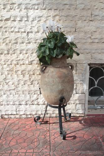 a large flower pot on a stand with a plant in it at Villa Axa in Casal Palocco