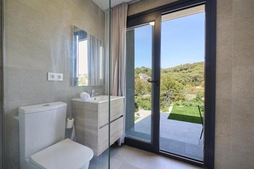 a bathroom with a toilet and a window with a view at 2Agnes01 in Vidreres
