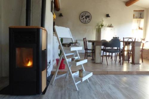 a living room with a fireplace and a table at Au Bregnat Vue du mont Ventoux in Bédoin