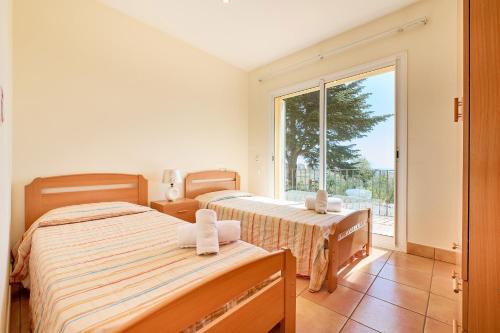 a bedroom with two beds and a large window at Villa Franci - Blanes in Blanes