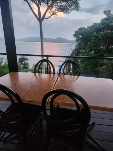 a table and chairs on a balcony with a view of the water at Le Bamboo Guest House And Boat Cruise in Hartbeespoort