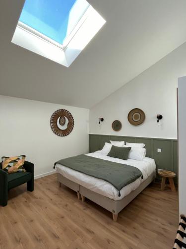 a bedroom with a large bed and a skylight at Le Chai in Nissan-lez-Enserune