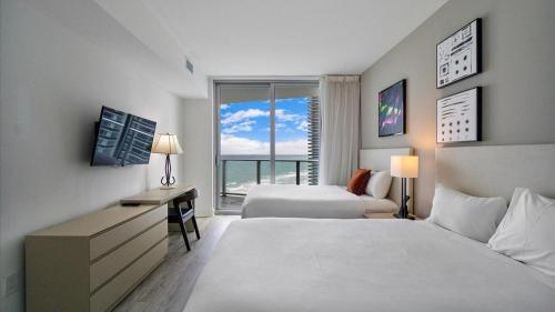 a hotel room with two beds and a window at 2 bed rental on the beach15th floor Hollywood Miami in Hallandale Beach