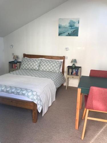a bedroom with a bed and a table and a chair at The Old Police House in Cheddar